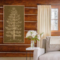 Carved Pine Tree Wall Art displayed in a cozy log cabin living room. The handcrafted wood artwork adds rustic lodge charm above a neutral sofa beside a vase of white flowers.