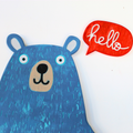 A blue bear-shaped wall hanging or decorative sign with a red speech bubble that says "hello" in white script, shown against a plain white background.