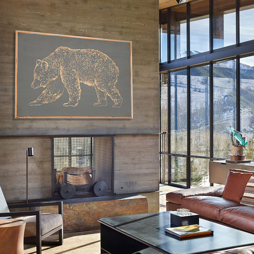 Framed carved bear wall art displayed above console in lodge-style interior