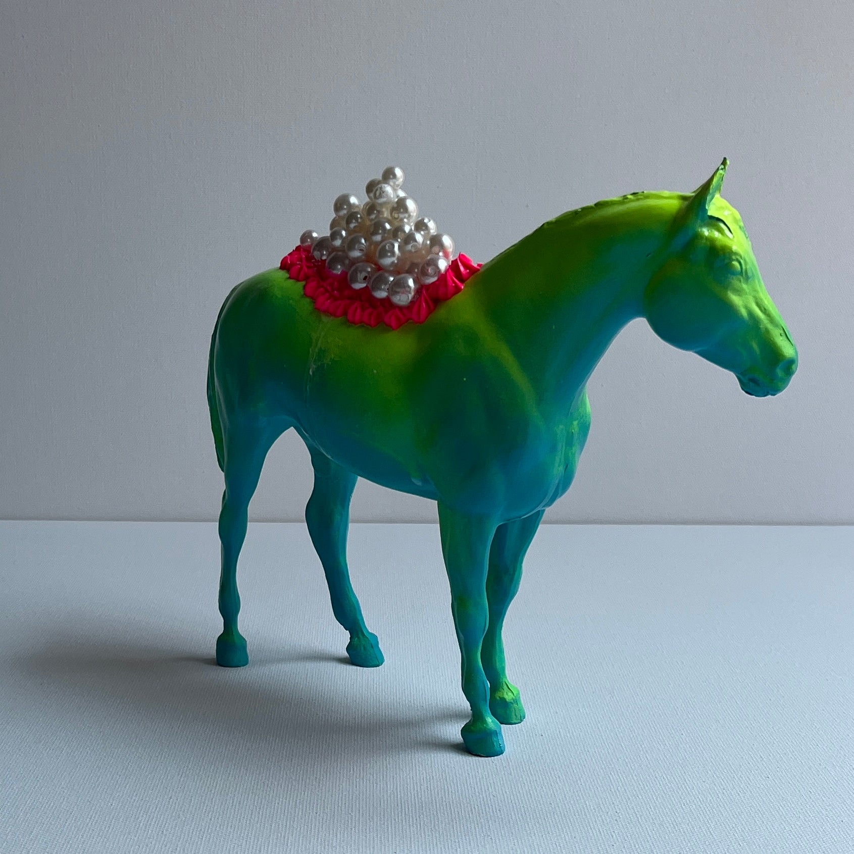 profile of blue horse with yellow and pink icing