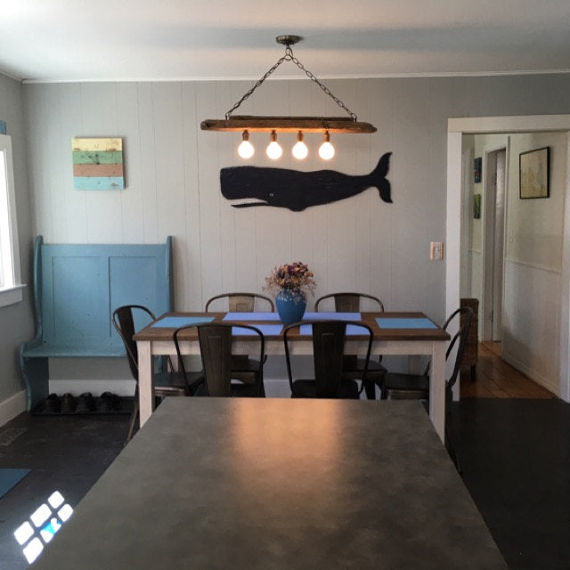 Handcrafted wooden Black whale wall decor in a coastal dining nook with nautical accents by Haven America